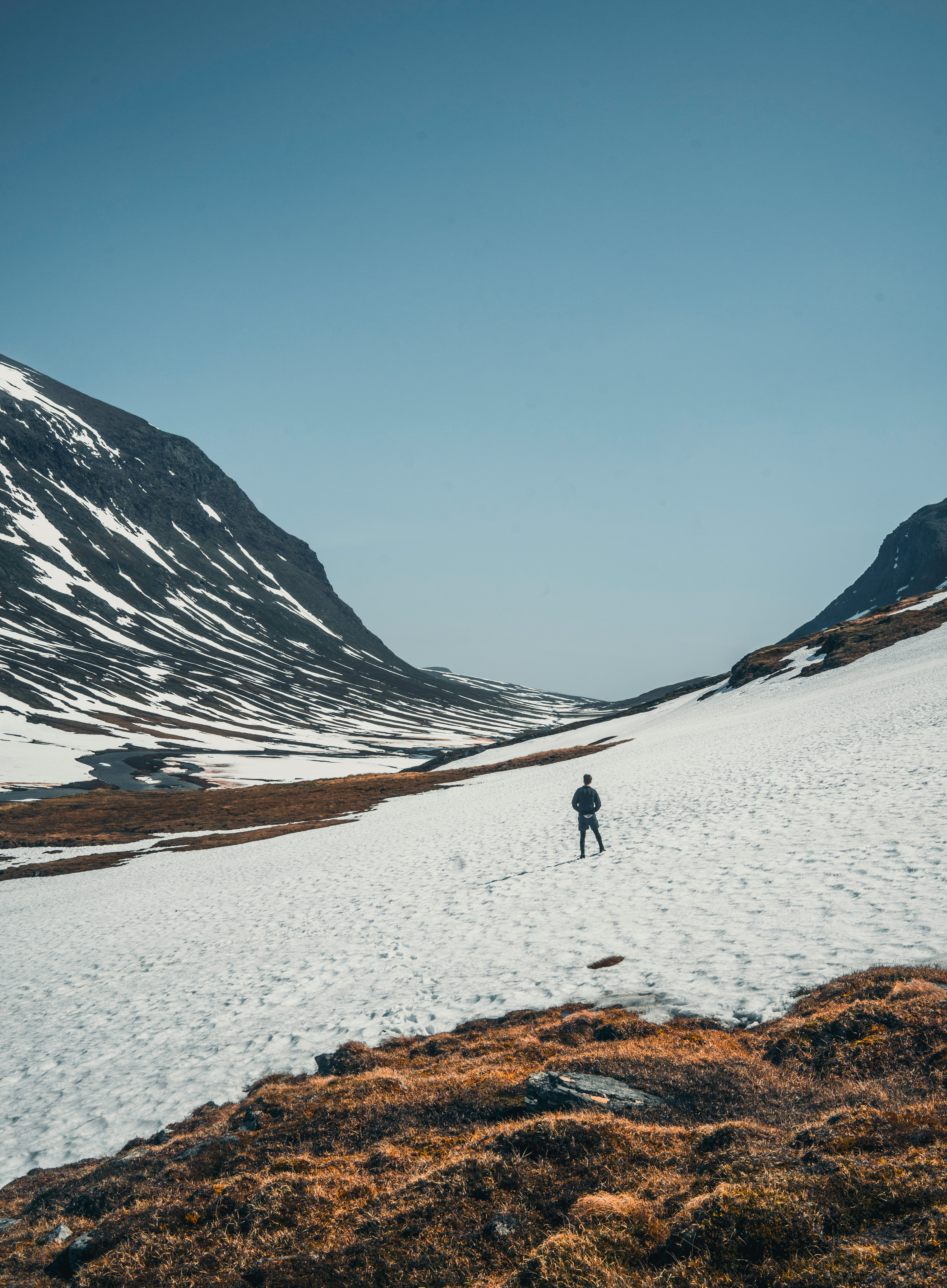 person walking on snow covered field during daytime